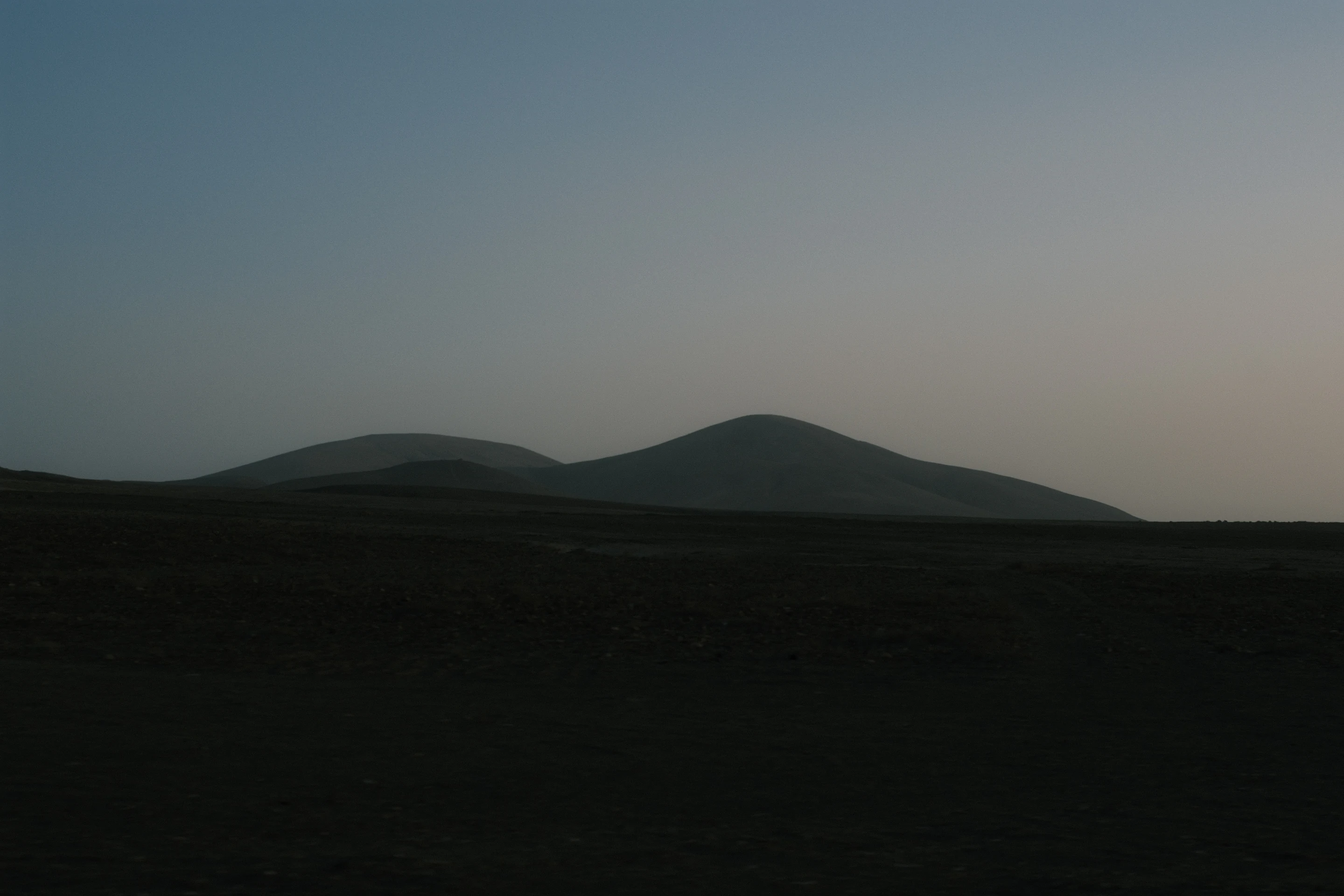 Low dusk landscape with soft hills silhouetted against a fading sky